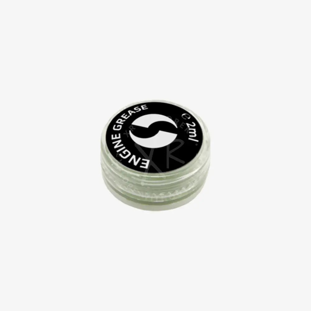A small clear plastic container with black lid holding 2ml of go drive system grease for engine lubrication
