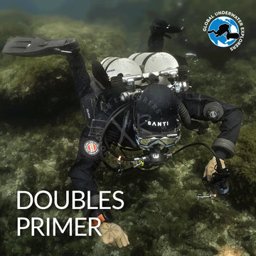 Black wetsuit with santi branding and circular logo on the arm paired with silver scuba gear with dual tanks for gue doubles primer