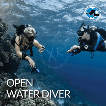 Two scuba divers in full gear including a black wetsuit with blue trim featured in gue open water diver rec 1 21m product