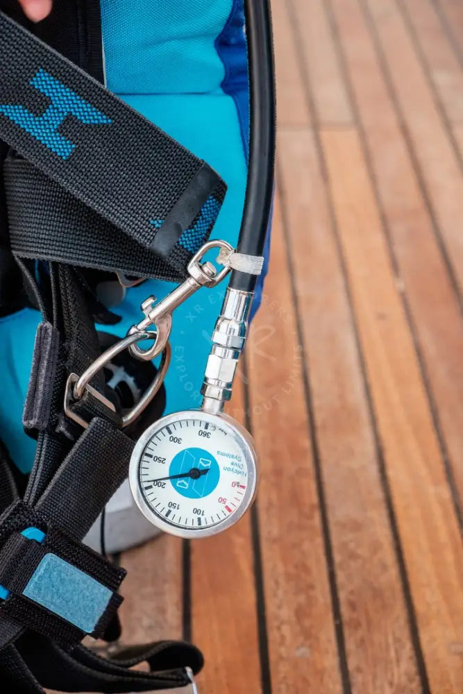 Halcyon bolt snap showing blue and white dive gauge attached to scuba tank with black straps