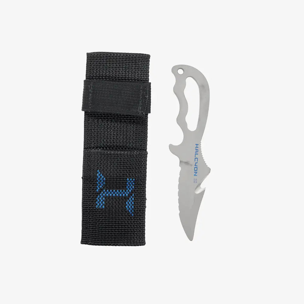 A titanium diving knife with a serrated and straight edge blade, featuring an ergonomic handle and a line cutter. The knife is accompanied by a sheath, and the blade is marked with a Halcyon logo.