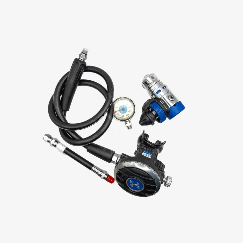 A diving regulator set with a black hose, black and silver regulator body, blue and silver valve assembly, and a round pressure gauge on a light gray background.