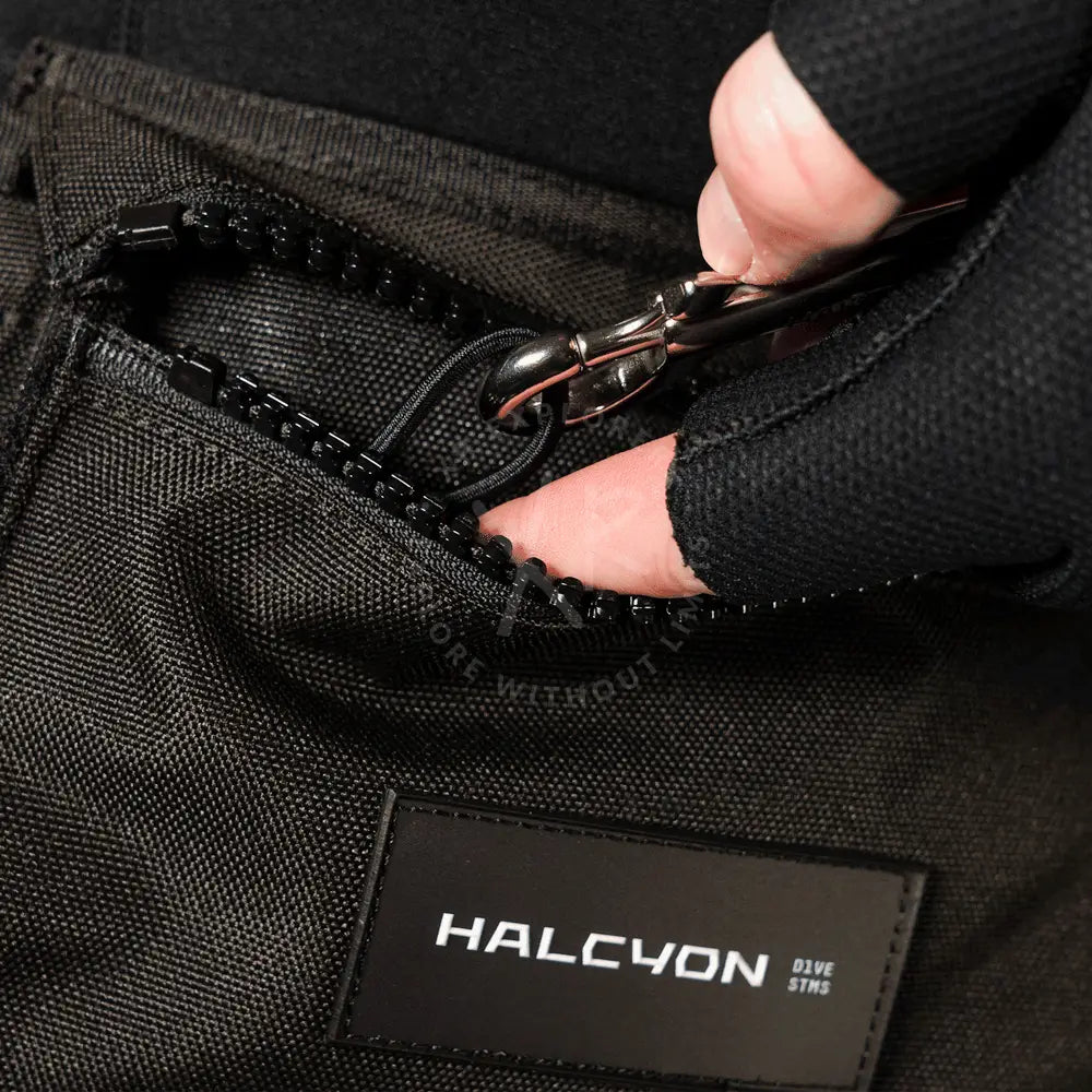 Black textured fabric pouch with black zipper and metallic pull tab labeled halcyon dive stms for neoprene cargo pockets