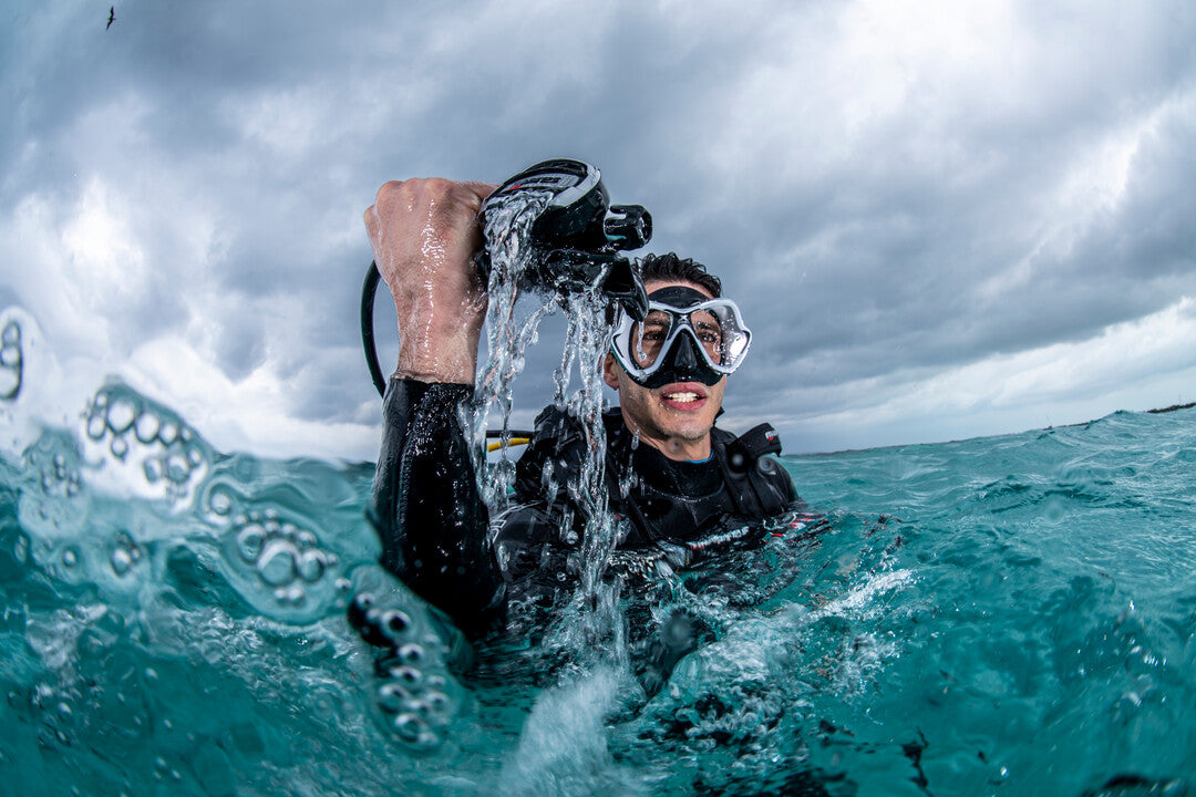 Promotional image for SSI Waves, Tides & Currents course featuring a diver in underwater environment with a large wave in the background.