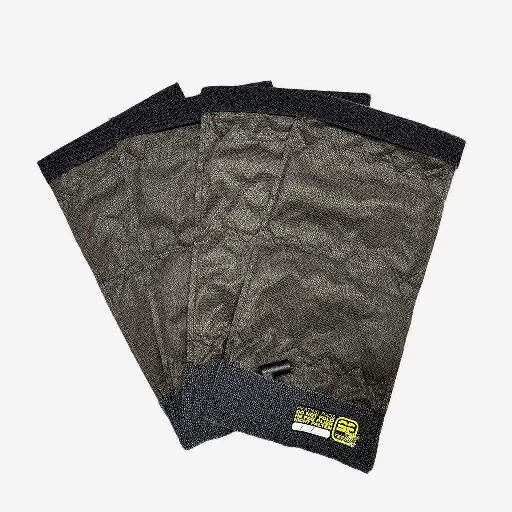 Four black heating pads with velcro attachments and a visible branded label, designed for integration into diving gear.