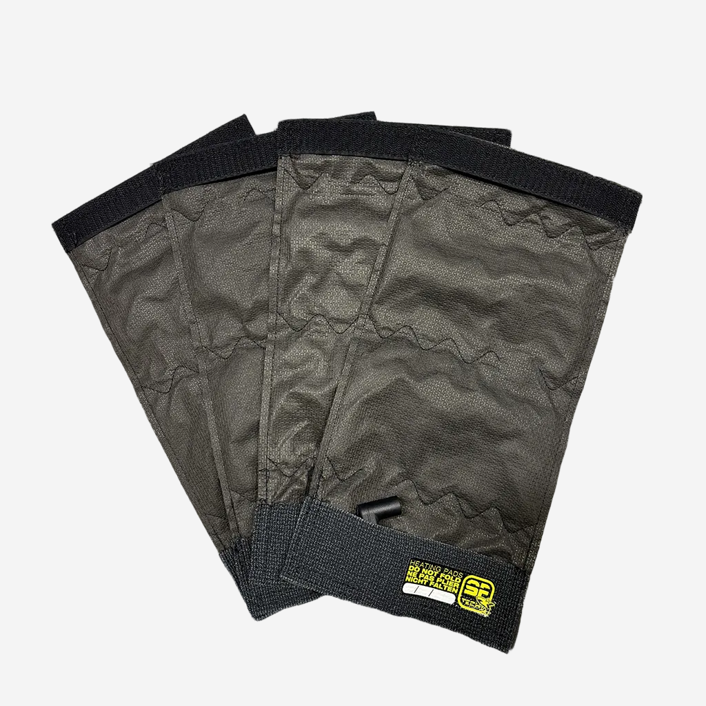 Four black heating pads with velcro attachments and a visible branded label, designed for integration into diving gear.