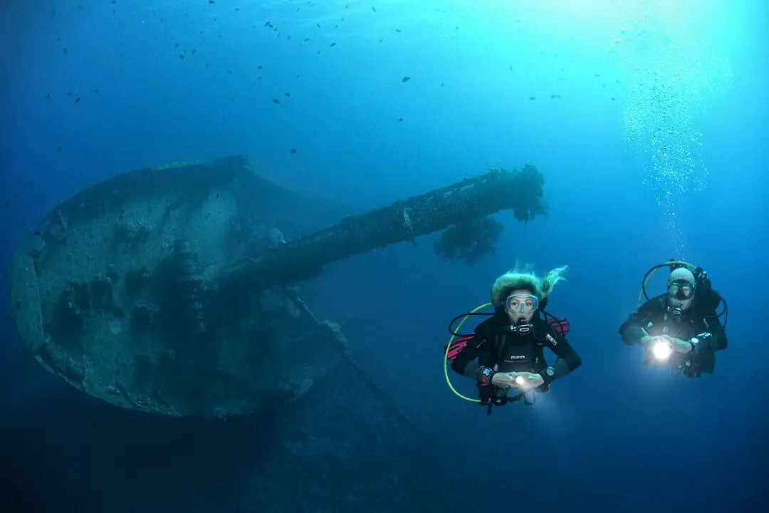 Dive guide leading a group underwater while maintaining team contact in Qatar