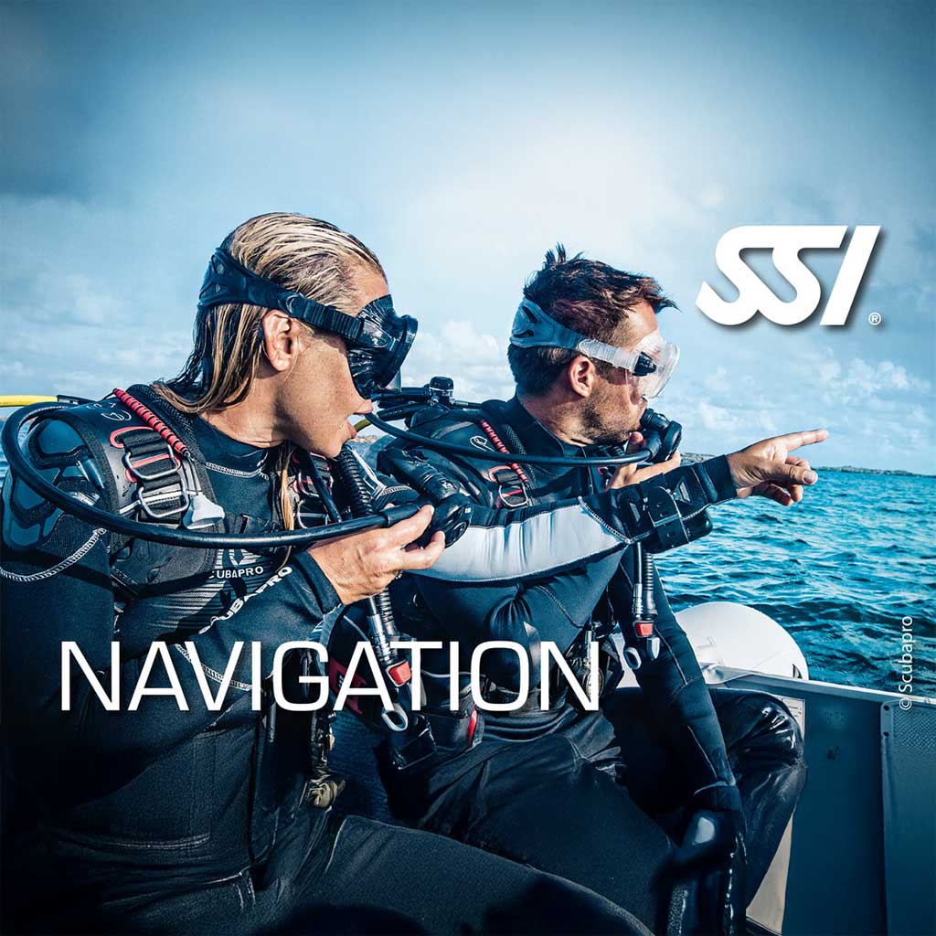 Two divers in underwater gear on a boat, with one pointing forward and the other looking at a compass, with the text 'NAVIGATION' and 'SSI' visible.