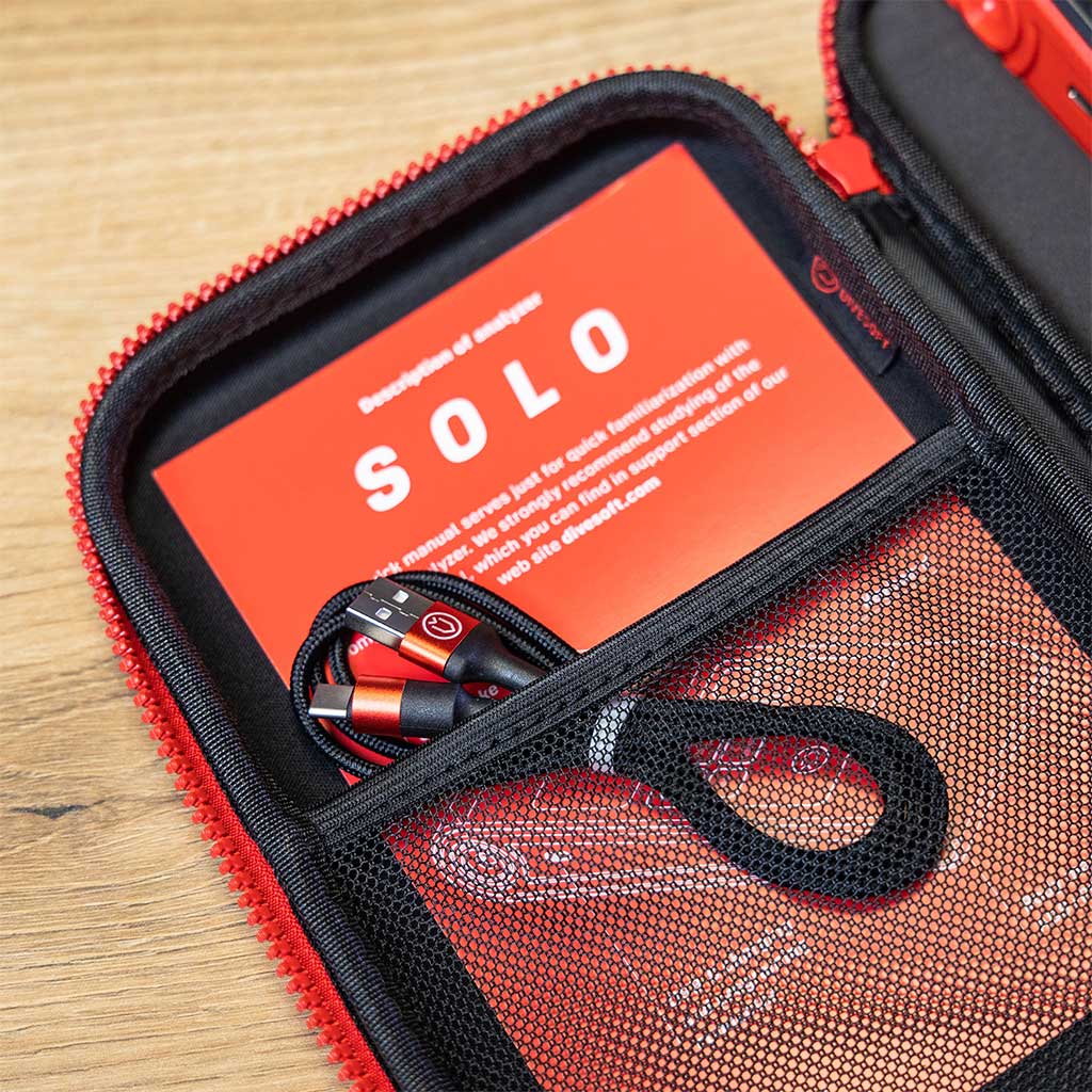 A Divesoft Analyzer SOLO, a handheld device for technical diving gas analysis with a digital screen and red detailing.