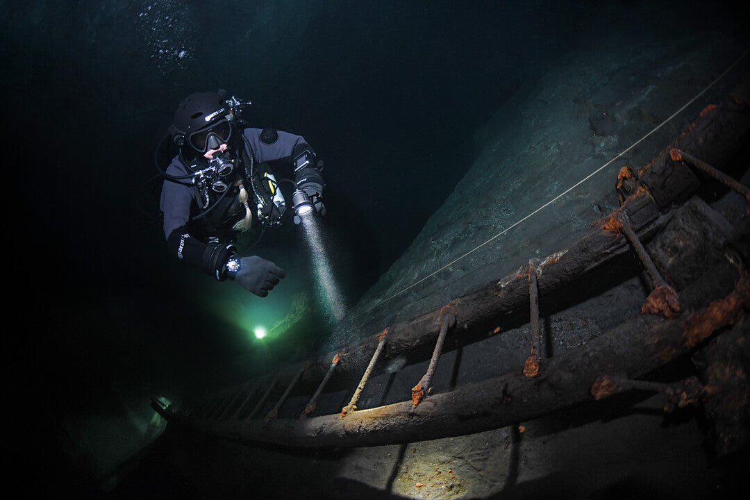 Diver using primary light for passive and active communication signals during night dive in Dubai