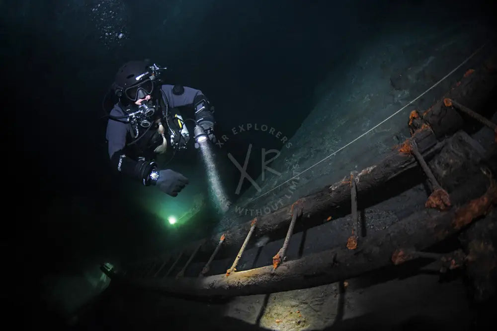 Diver using primary light for passive and active communication signals during night dive in Dubai