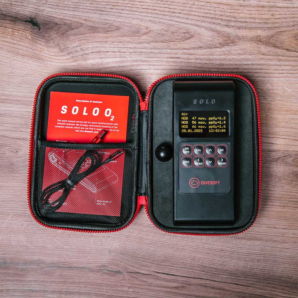 Charging the Divesoft SOLO O2 via USB-C cable alongside diving gear in Qatar