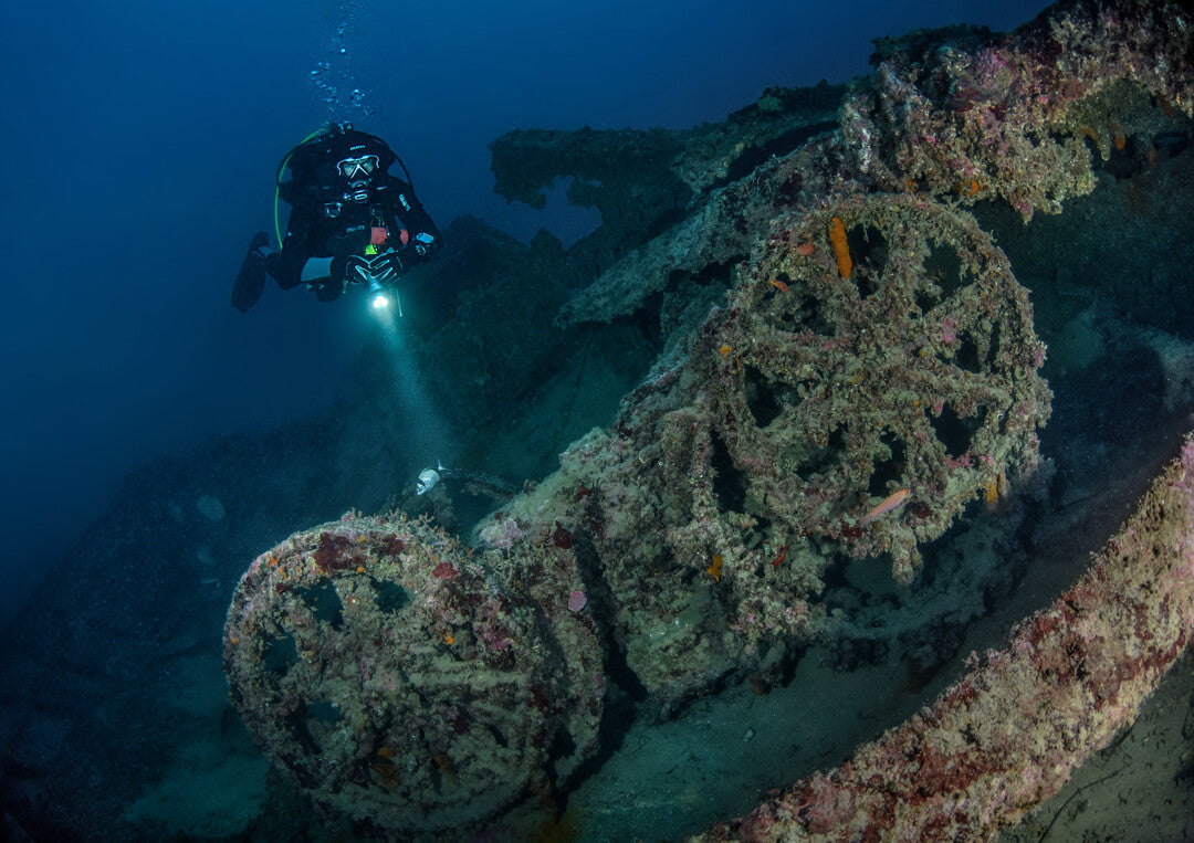 Dive team using light signals to communicate while exploring a wreck in Dubai with XR Explorers
